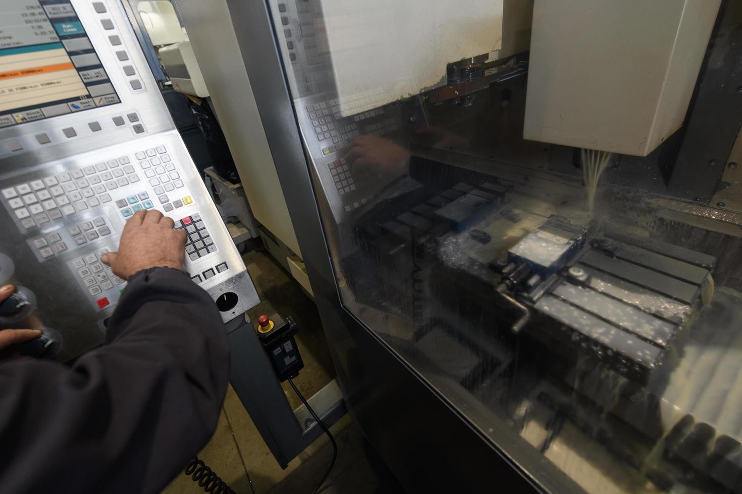 close up a worker hand or engineer introducing a program into a modern CNC machine. The concept of industry and engineering. photo