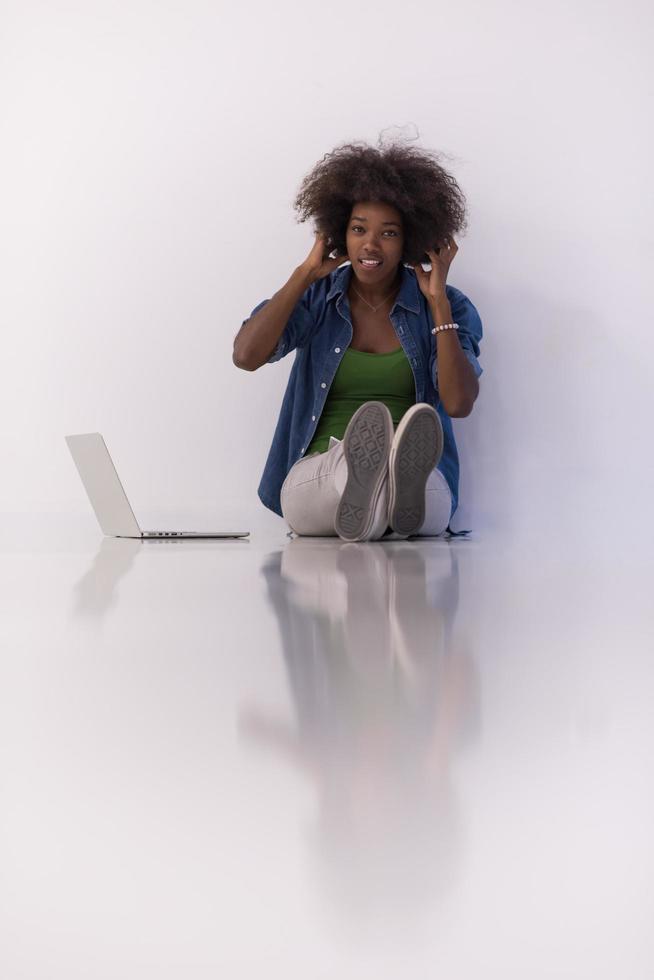 african american woman sitting on floor with laptop photo