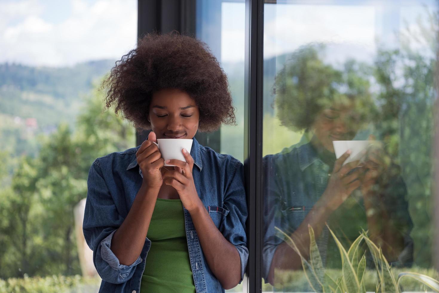 African American woman drinking coffee looking out the window photo