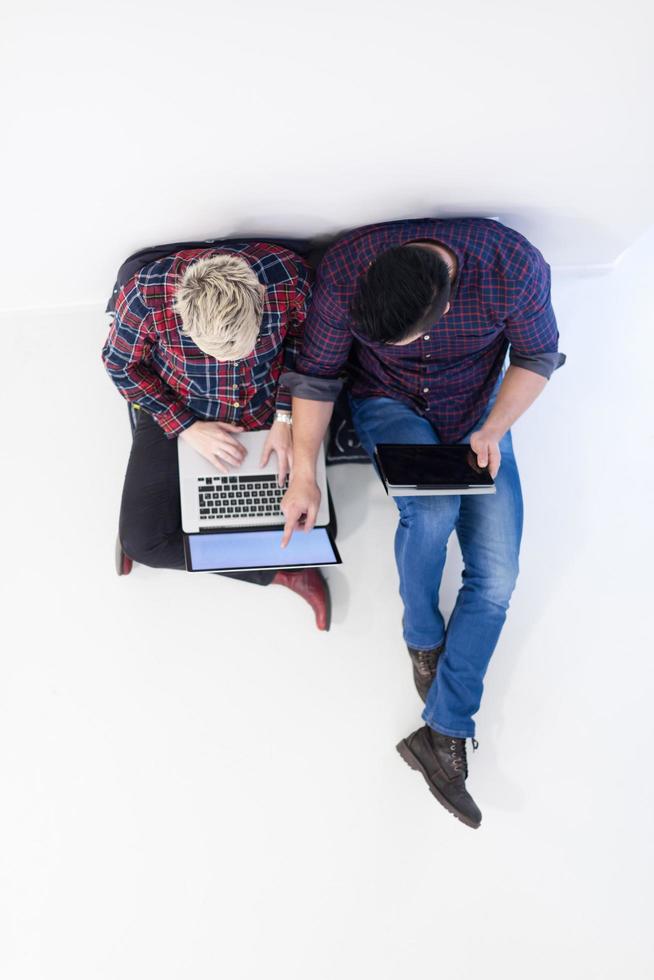 top view of  couple working on laptop computer at startup office photo