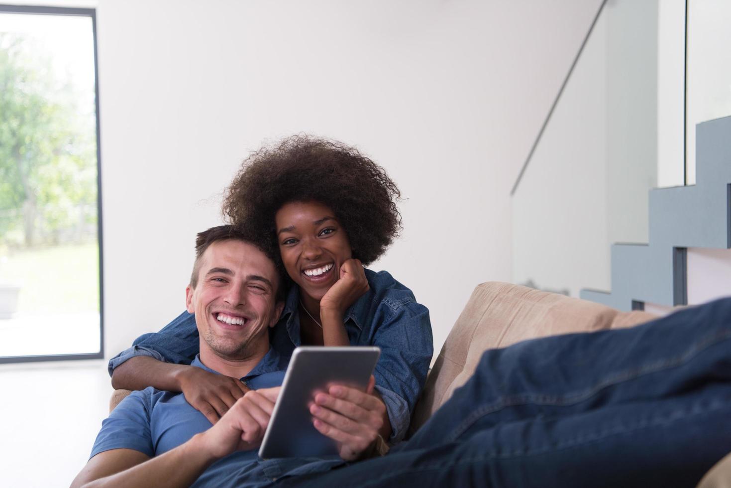 multiethnic couple relaxing at  home with tablet computers photo