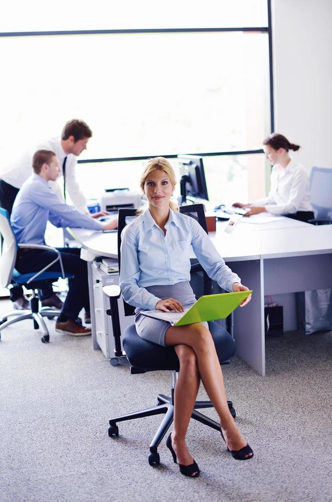 business woman with her staff in background at office photo