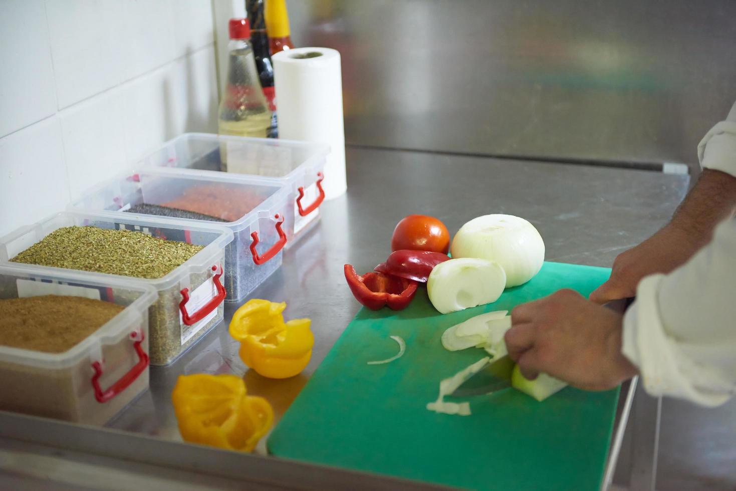 chef in hotel kitchen  slice  vegetables with knife photo