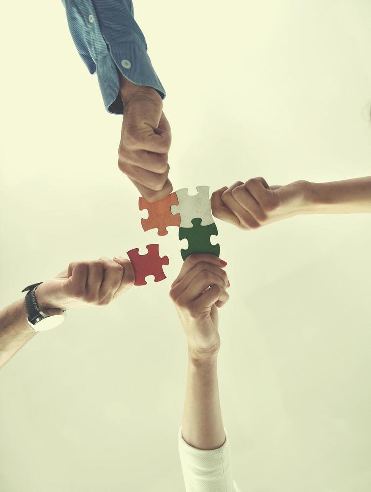 Group of business people assembling jigsaw puzzle photo