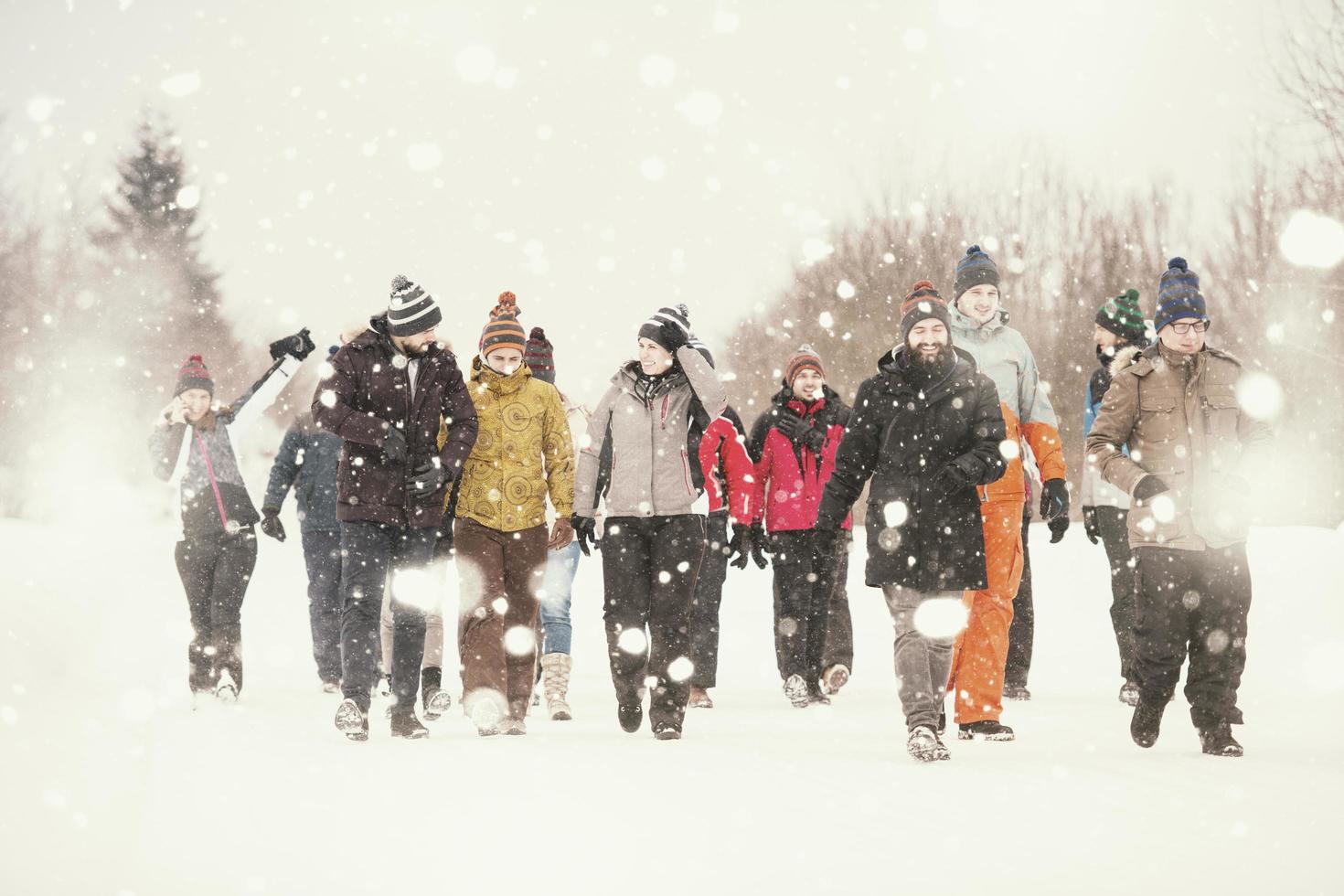 group of young people walking through beautiful winter landscape photo