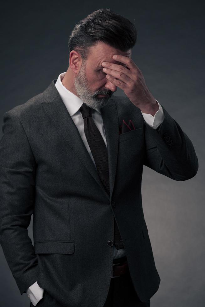 Frustrated middle aged elegant man Close up face of stressed businessman wearing stylish suit with eyes closed. Overworked middle eastern business man with terrible migrain photo