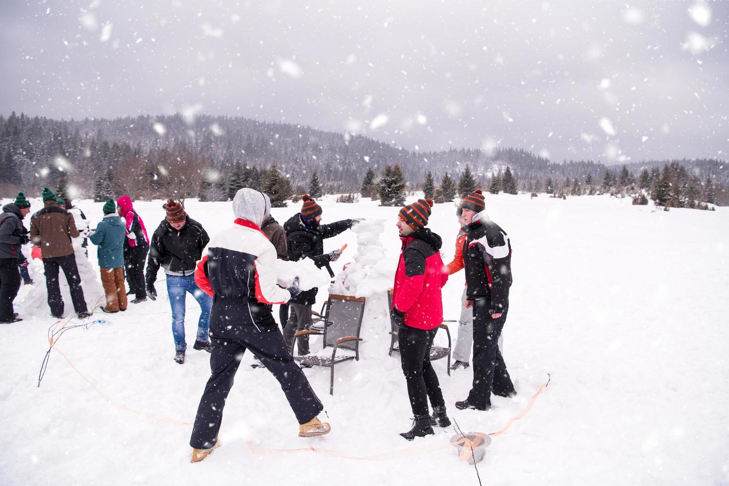 group of young people making a snowman photo