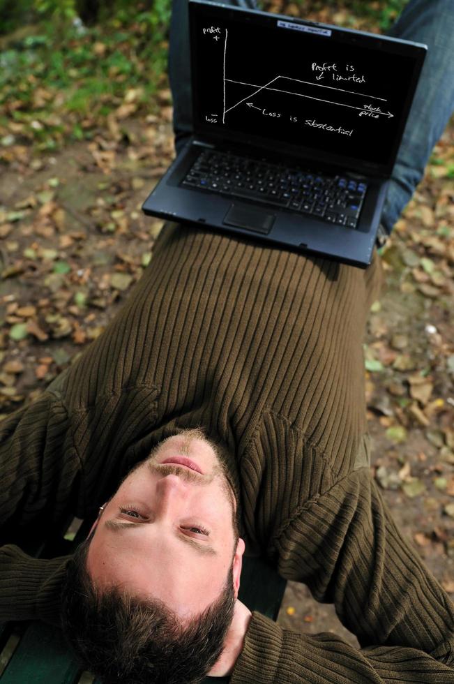 young businessman working on laptop outdoor photo