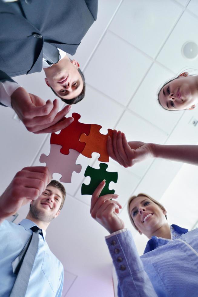 Group of business people assembling jigsaw puzzle photo