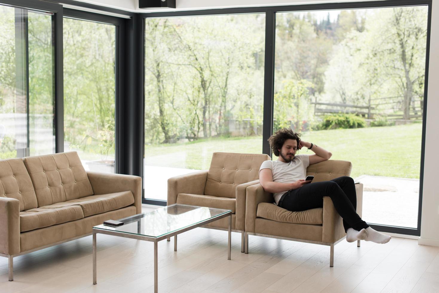 young man using a mobile phone  at home photo