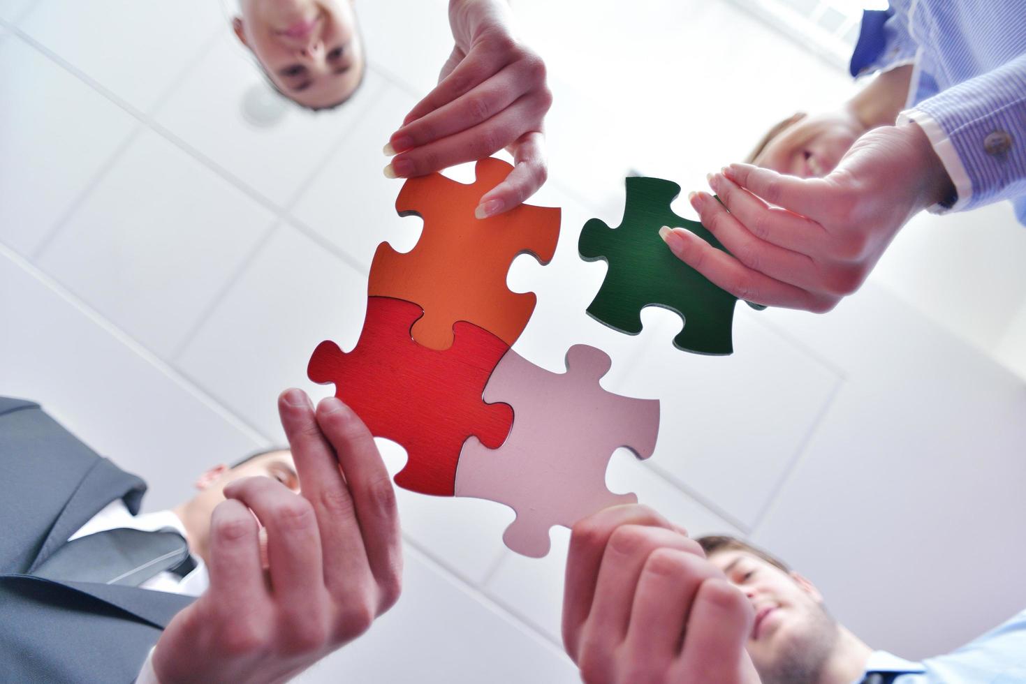 Group of business people assembling jigsaw puzzle photo