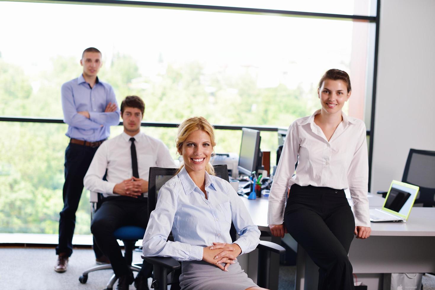 business woman with her staff in background at office photo