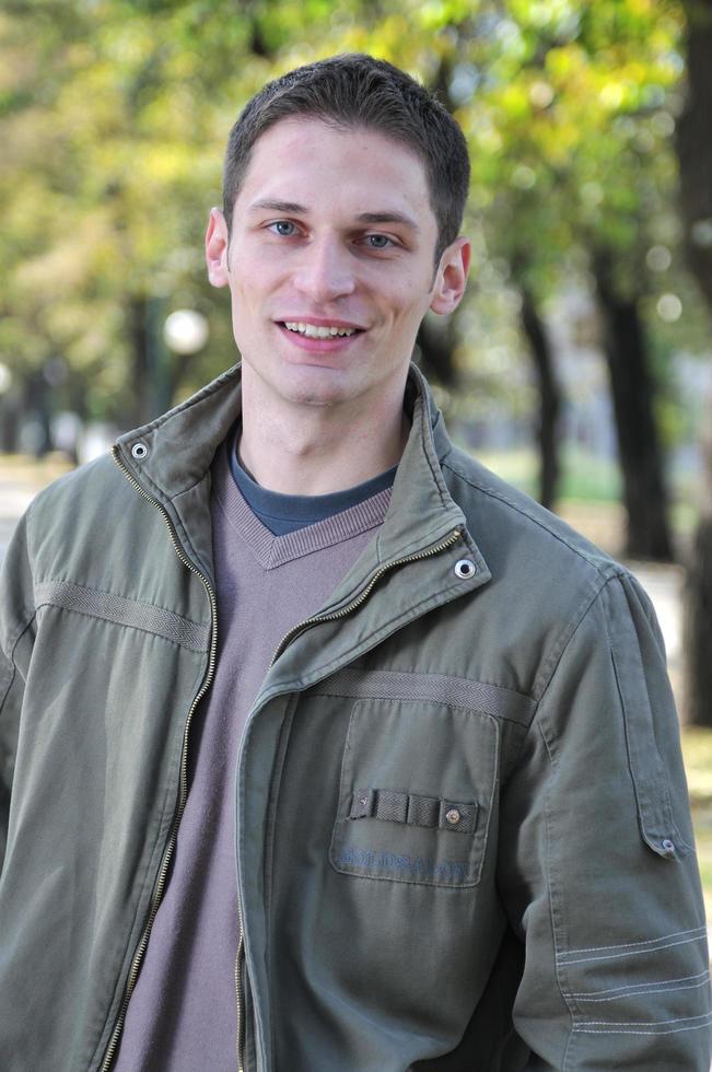 Handsome young man smiling outdoors photo