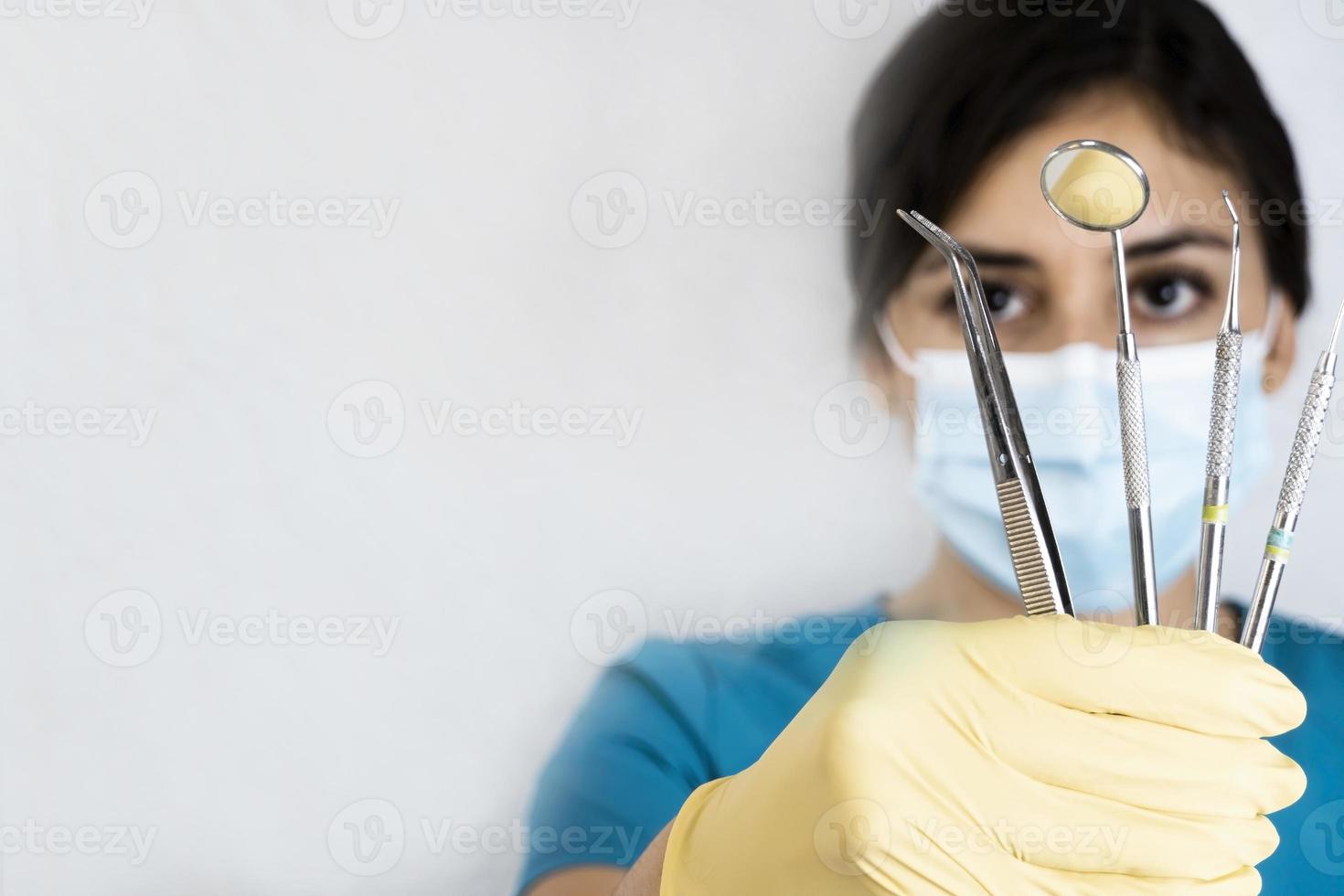 Espíritu Favor jueves joven dentista sosteniendo instrumentos dentales en la mano 12149743 Foto  de stock en Vecteezy