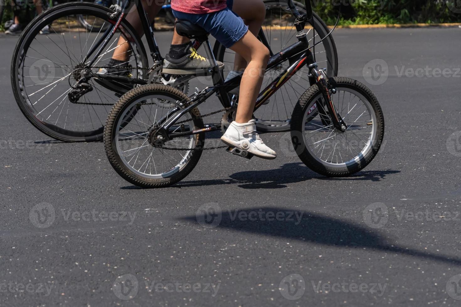 young man with customized bicycle shows off his style riding down the street on a sunny day. photo