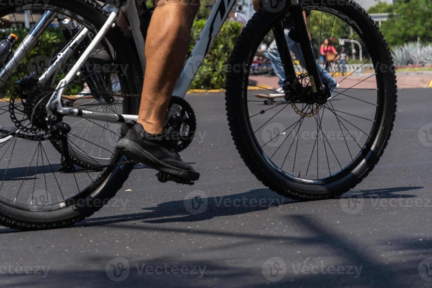un joven con una bicicleta personalizada muestra su estilo recorriendo la calle en un día soleado. foto