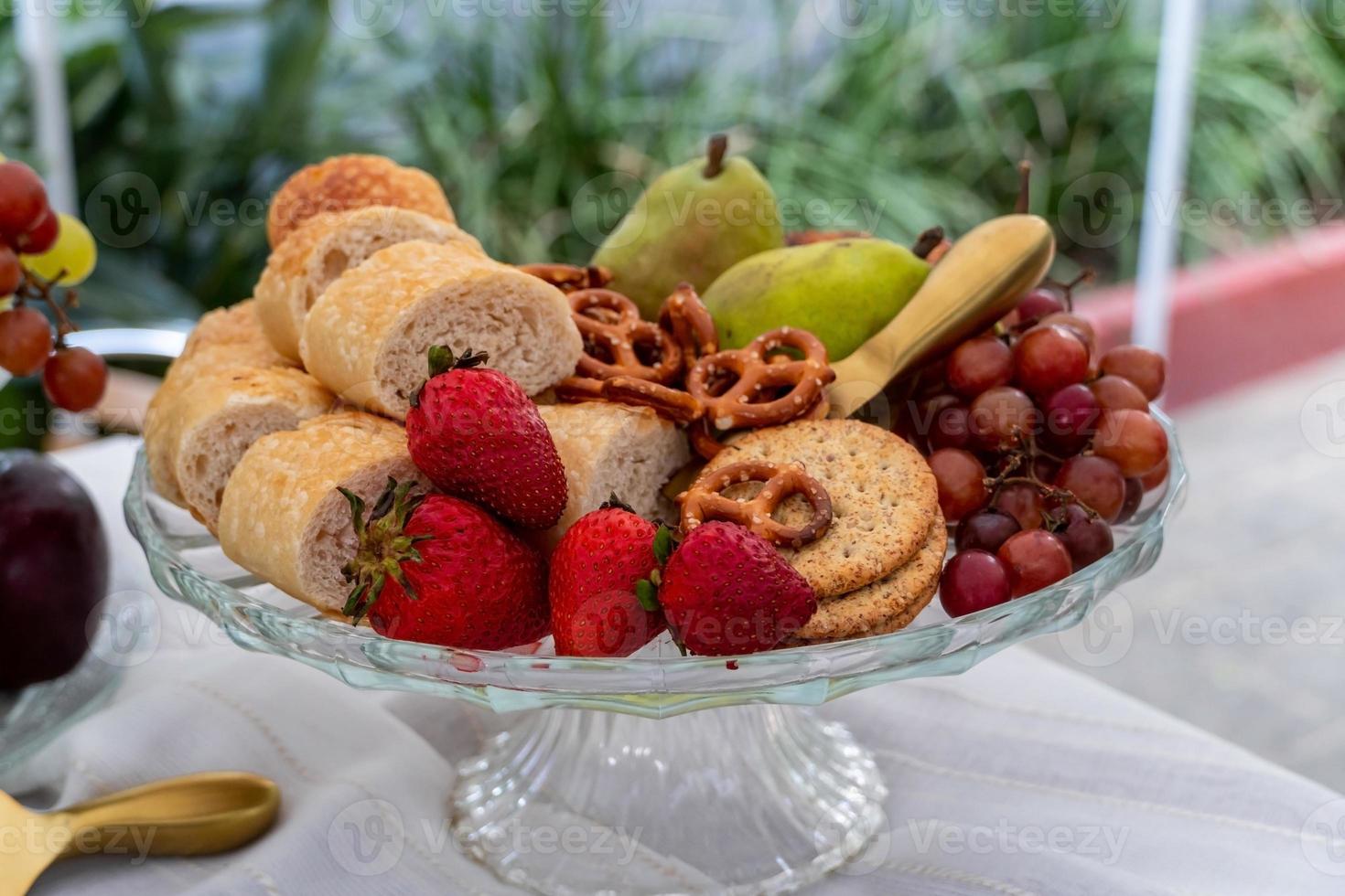 glass fruit basket, Picninc outside. out of focus vegetation in the background. photo