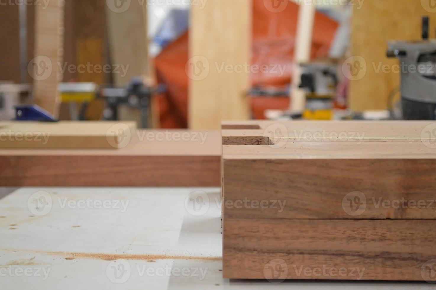 A man cuts wood on a circular saw in a joinery, band saw, holding a plank photo