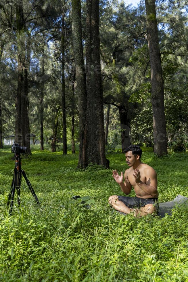 View of a man conducting virtual fitness class with group of people at home on a video conference. Fitness instructor taking online yoga classes photo