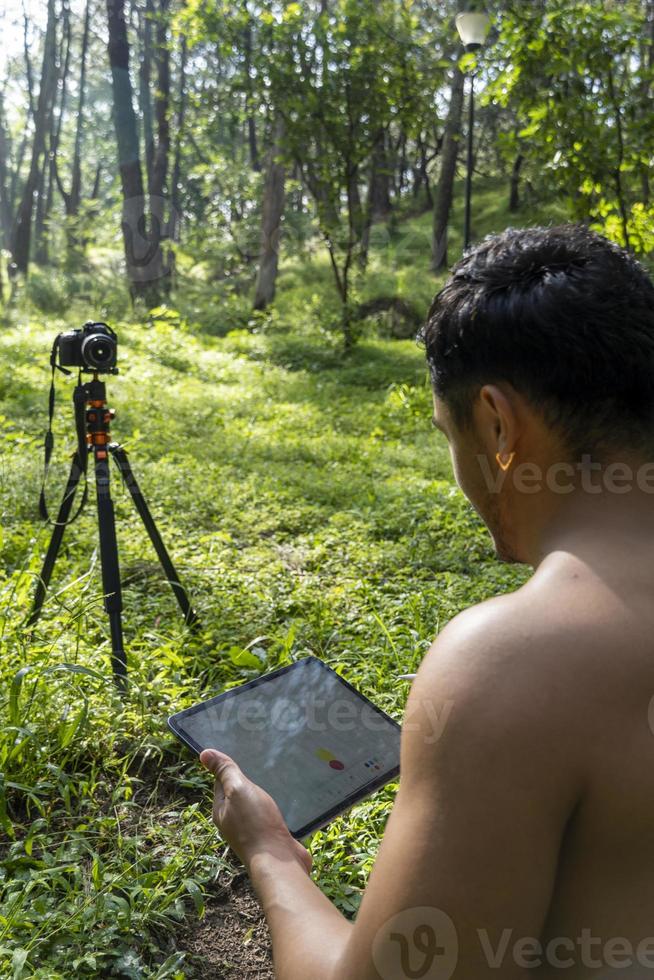 young man explaining drawing on his tablet, while teaching chakra, yoga and meditation class, mexico photo