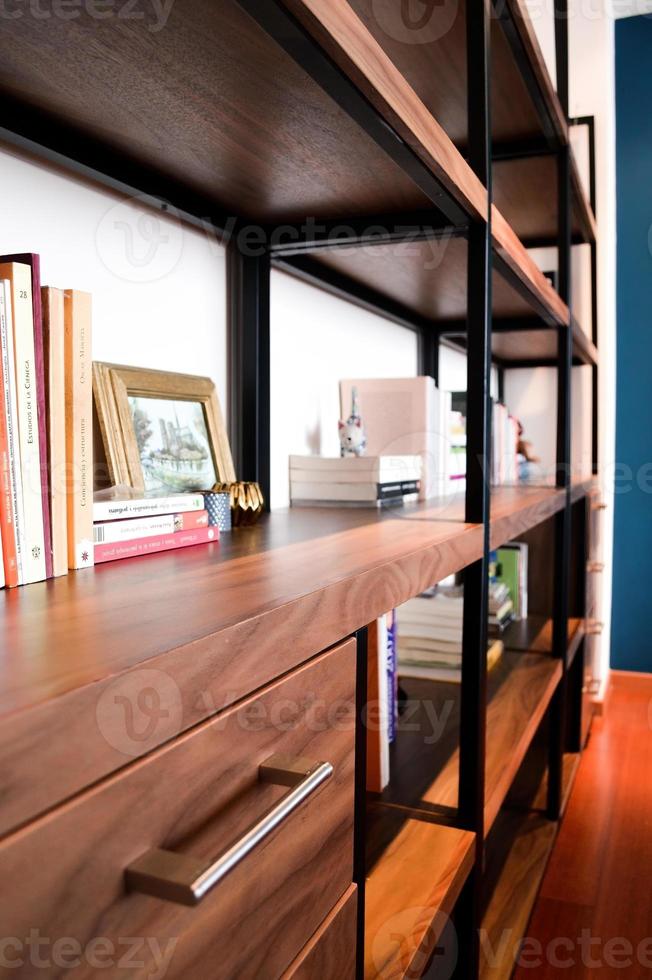 metal and wood bookcase, with drawers person in front passing photo