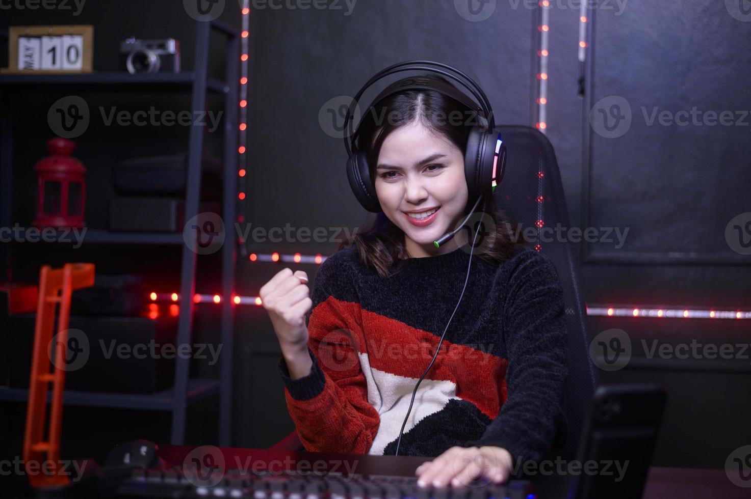 Young female professional Streamer and gamer with headset playing online video games photo