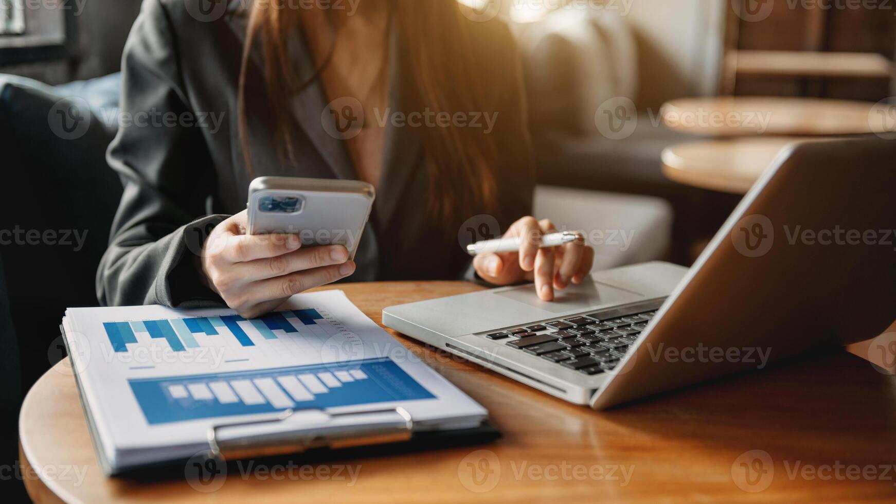 business documents on office table with smart phone and digital tablet and graph financial and woman working at office photo