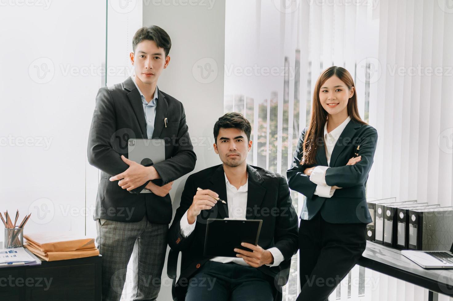 socios comerciales sentados en la oficina y sonriendo a la cámara. ejecutivos exitoso equipo de negocios foto