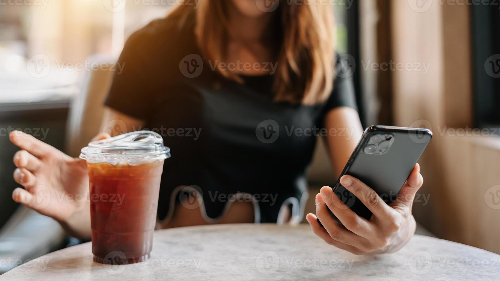 Beautiful asian woman holding and using digital tablet while drinking coffee at home office and cafe photo