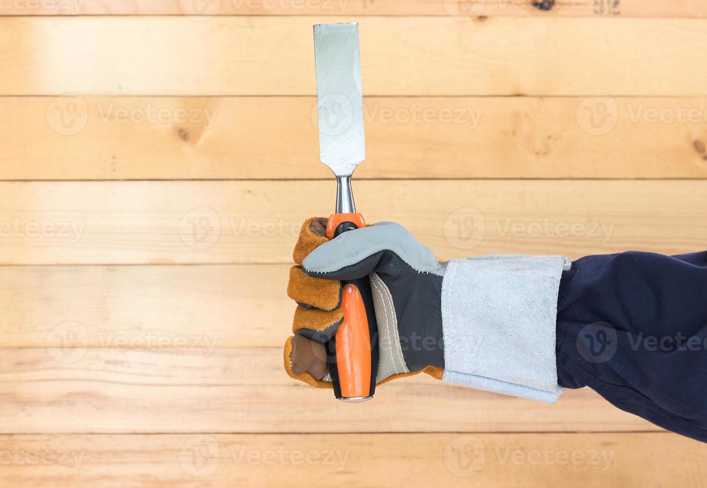 Hand in glove holding chisel photo