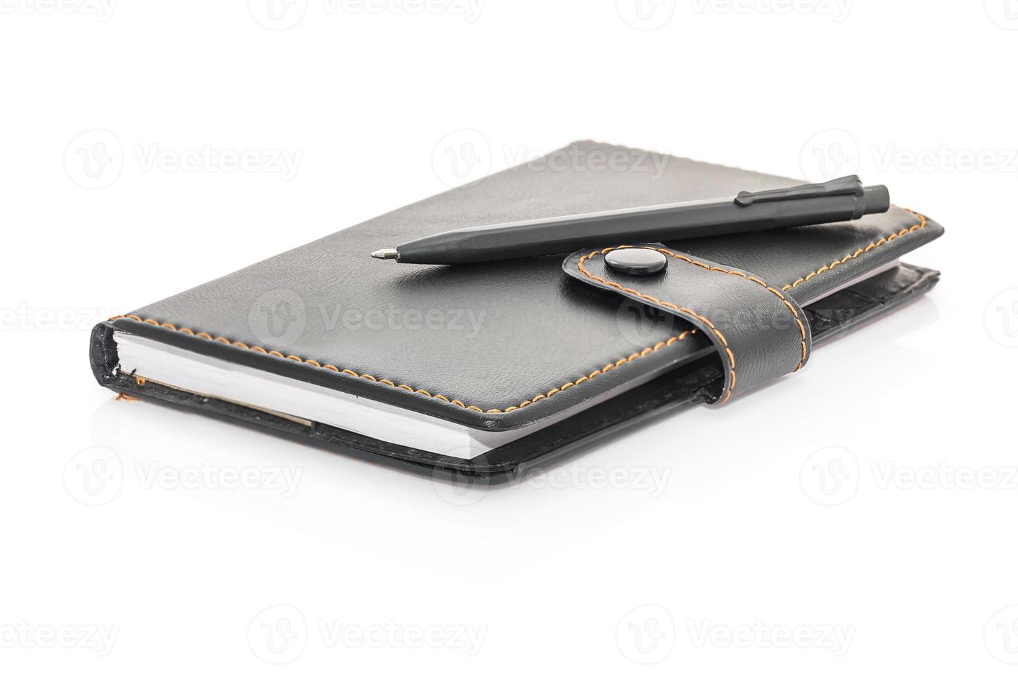 Black leather note book and pen on white photo