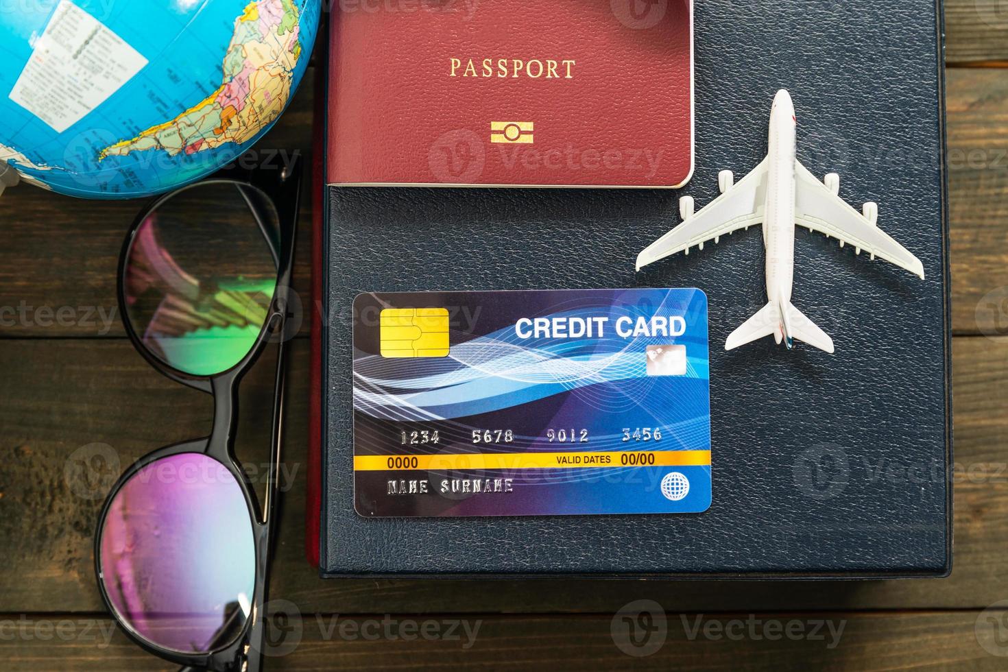 Credit card and airplane model on wooden table photo