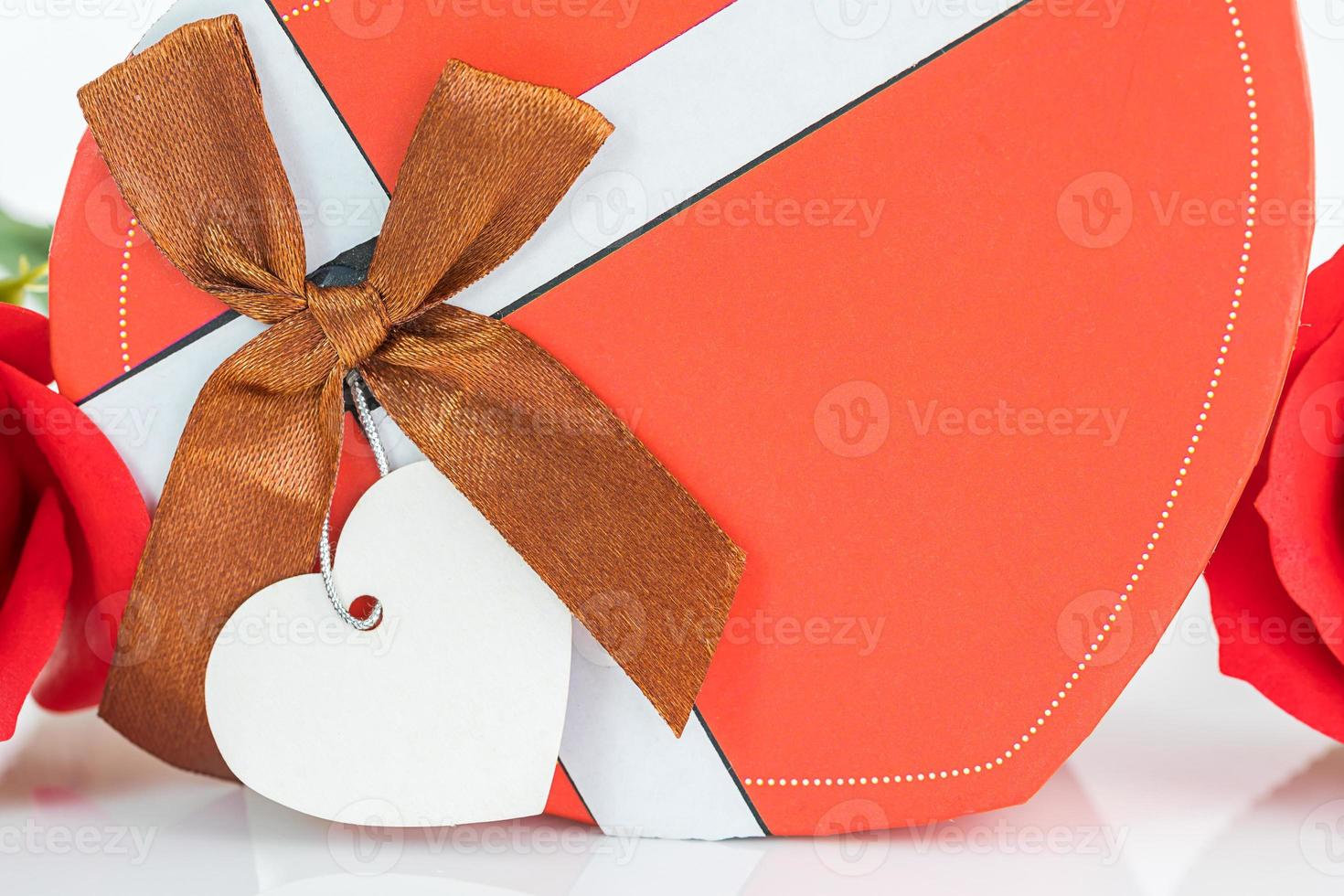 Red roses and heart shaped box on white photo