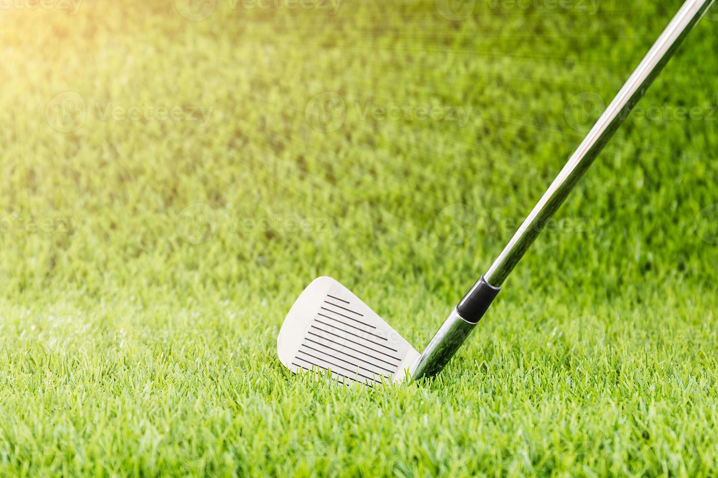 Golf club on green grass with sunlight photo