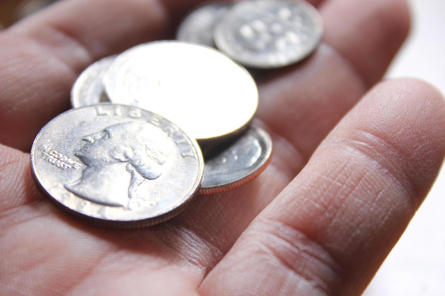 Quarters and Dime coins are the currency of America. In the hands of men. photo