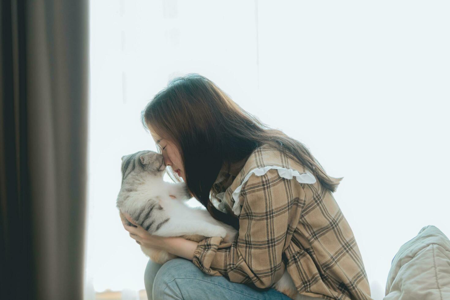 Portrait of young woman holding cute cat. Female hugging her cute long hair kitty. Background, copy space, close up. Adorable domestic pet concept. photo