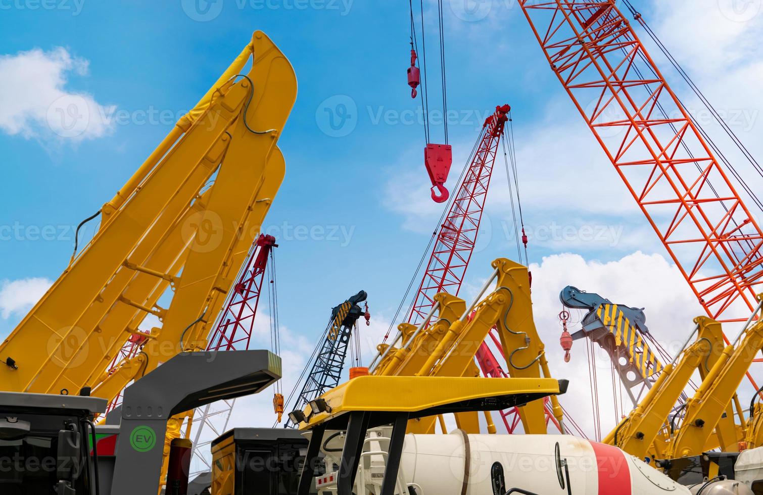 Crawler crane against blue sky. Real estate industry. Red crawler crane use reel lift up equipment in construction site. Crane for rent at parking lot. Crane dealership for construction business. photo