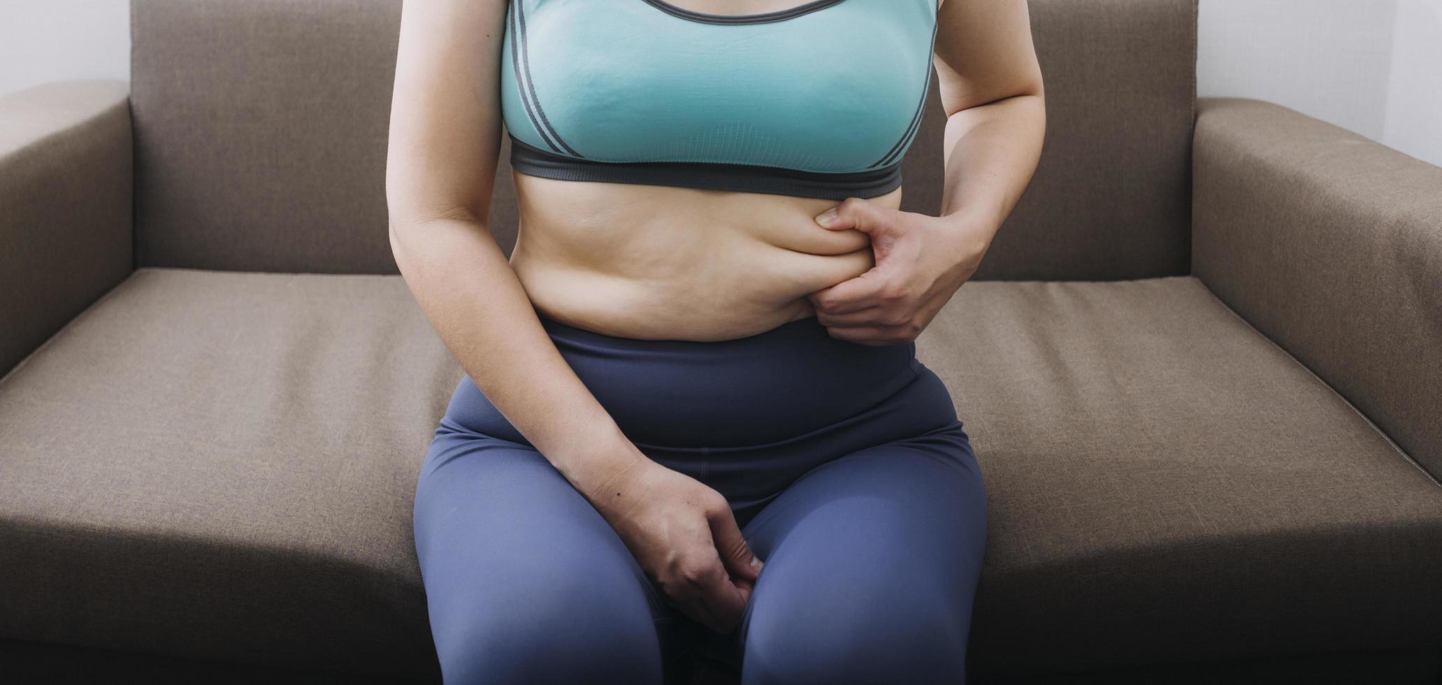 Beautiful fat woman with tape measure She uses her hand to squeeze the excess fat that is isolated on a white background. She wants to lose weight, the concept of surgery and break down fat under the photo