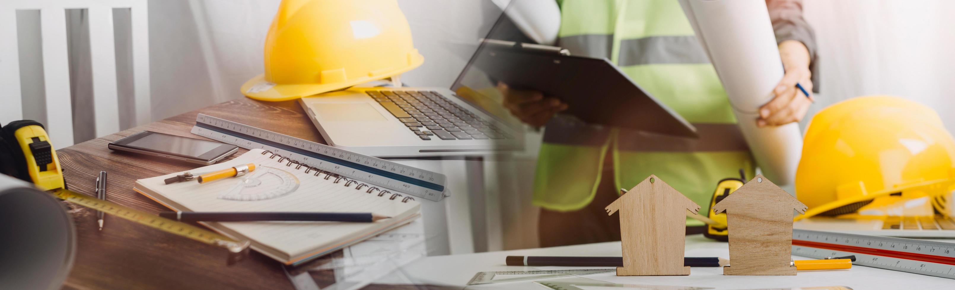 Two colleagues discussing data working and tablet, laptop with on on architectural project at construction site at desk in office photo