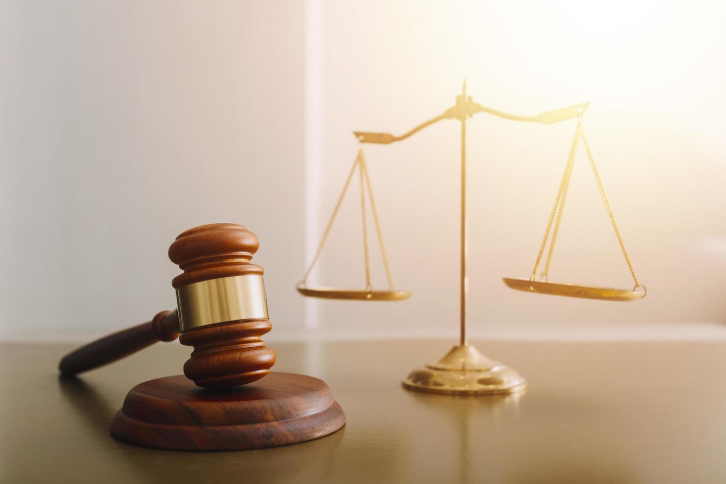 Justice and law concept.Male judge in a courtroom with the gavel, working with, computer and docking keyboard, eyeglasses, on table in morning light photo