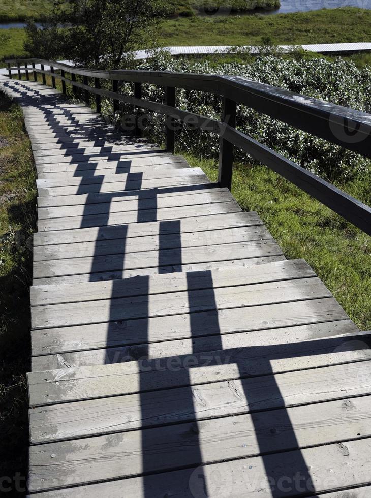 The midday sun creating an interesting pattern on a pathway through Thingvellir, Iceland photo