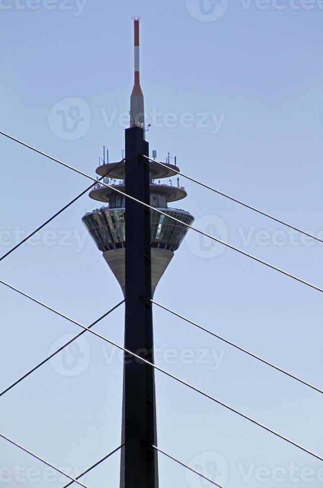 Rheinturm in Dusseldorf half hidden behind a bridge photo