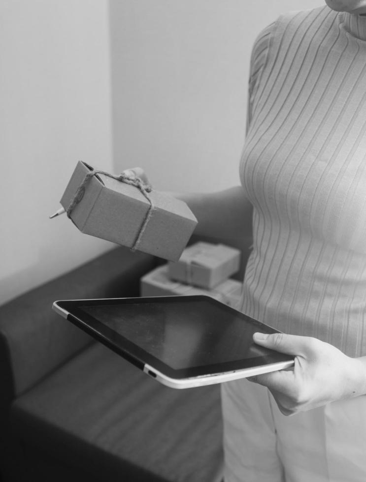 Startup SME small business entrepreneur of freelance Asian woman using a laptop with box Cheerful success Asian woman her hand lifts up online marketing packaging box and delivery SME idea concept photo
