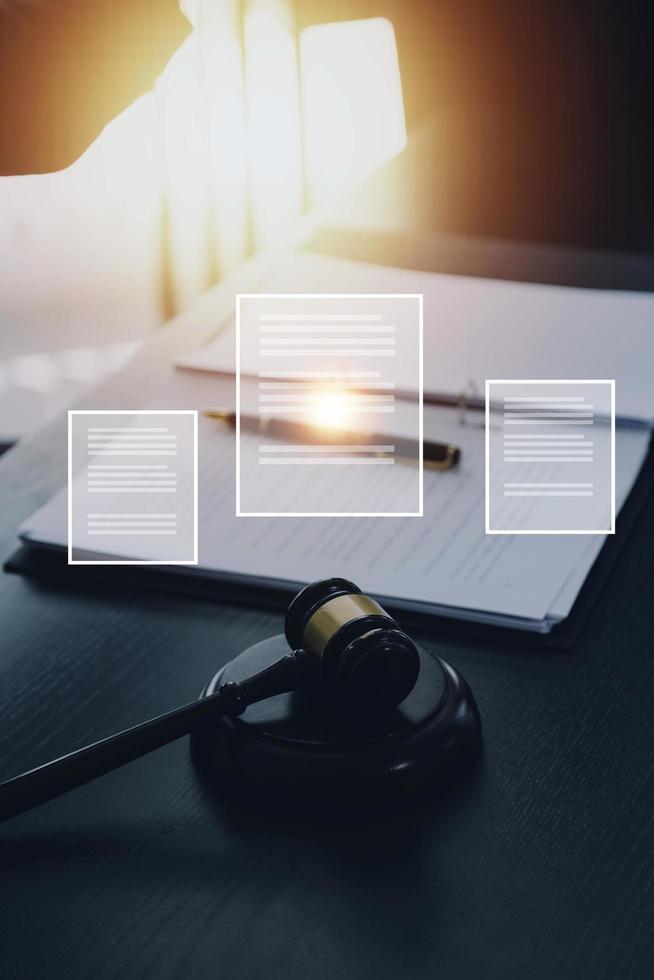 Justice and law concept.Male judge in a courtroom with the gavel, working with, computer and docking keyboard, eyeglasses, on table in morning light photo