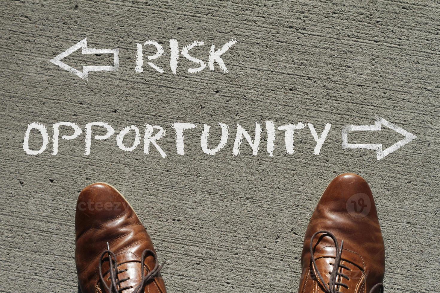 Top view on a man standing in front of the words Risk and Opportunity with arrows pointing to the left and right side of the picture photo