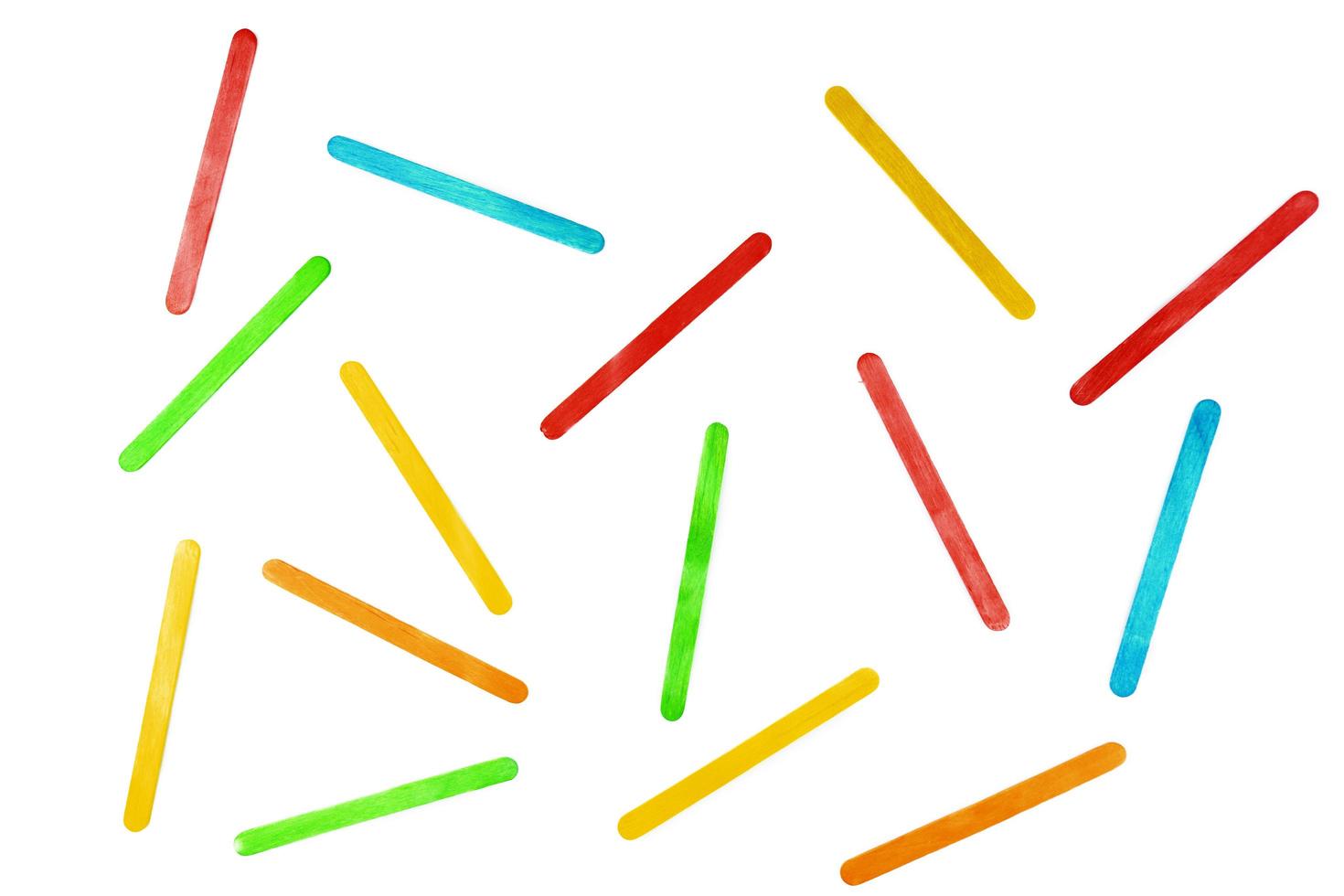 Multicolored wooden sticks lying on a white background photo