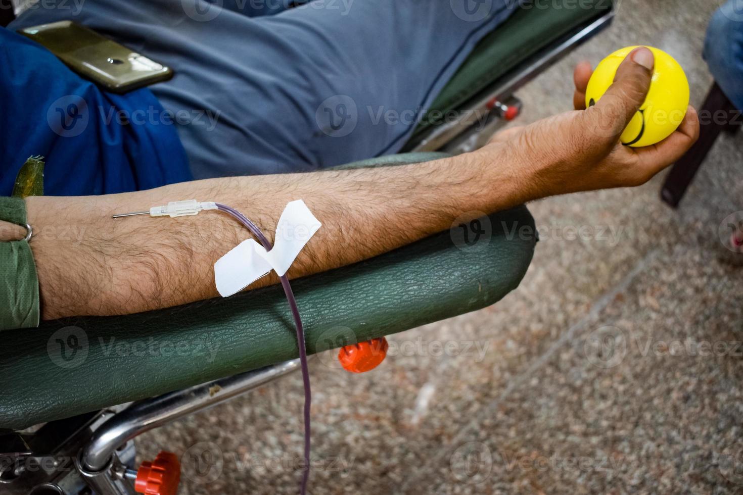 donante de sangre en el campamento de donación de sangre sostenido con una pelota hinchable en la mano en el templo balaji, vivek vihar, delhi, india, imagen para el día mundial del donante de sangre el 14 de junio de cada año, campamento de donación de sangre foto