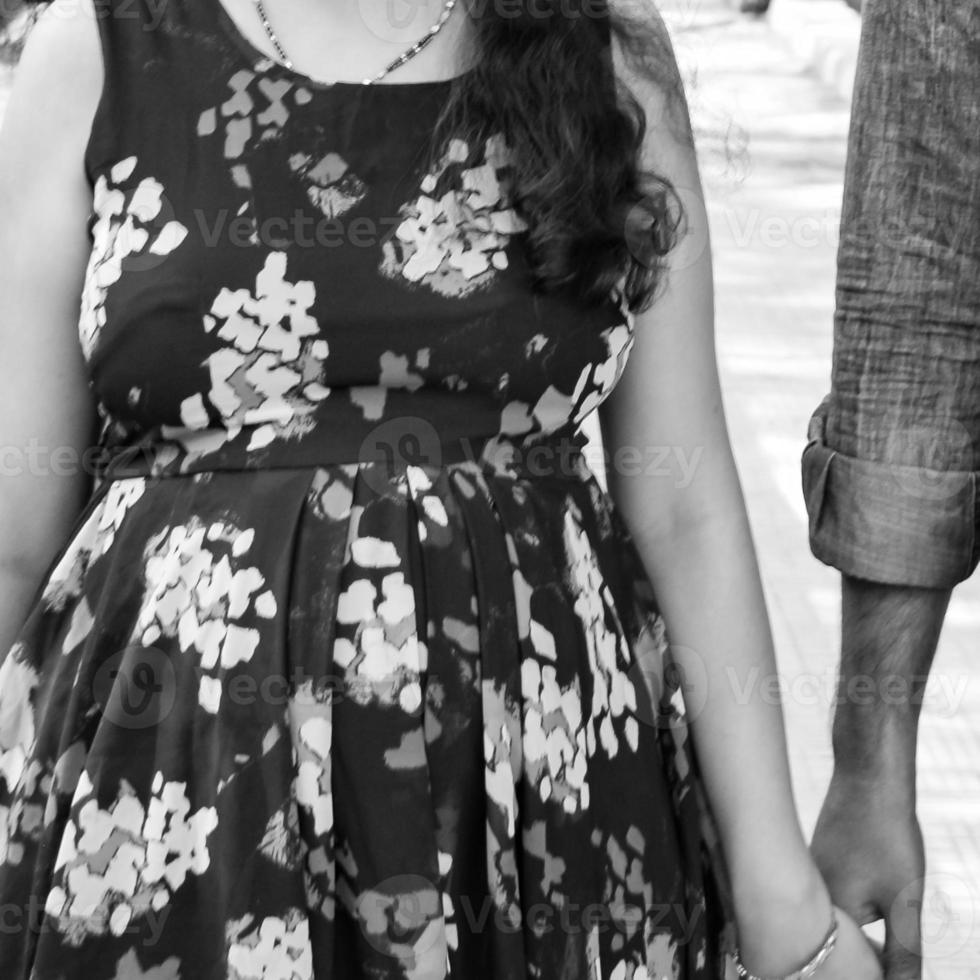 pareja india posando para una sesión de fotos de maternidad. la pareja está posando en un césped con hierba verde y la mujer está faluntando su panza en el jardín de lodhi en nueva delhi, india - blanco y negro