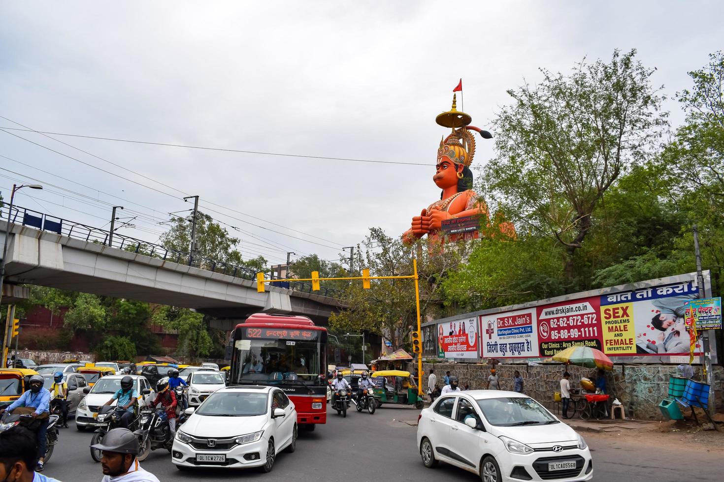 New Delhi, India - June 21, 2022 - Big statue of Lord Hanuman near the delhi metro bridge situated near Karol Bagh, Delhi, India, Lord Hanuman statue touching sky photo
