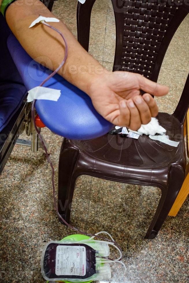 Blood donor at Blood donation camp held with a bouncy ball holding in hand at Balaji Temple, Vivek Vihar, Delhi, India, Image for World blood donor day on June 14 every year, Blood Donation Camp photo